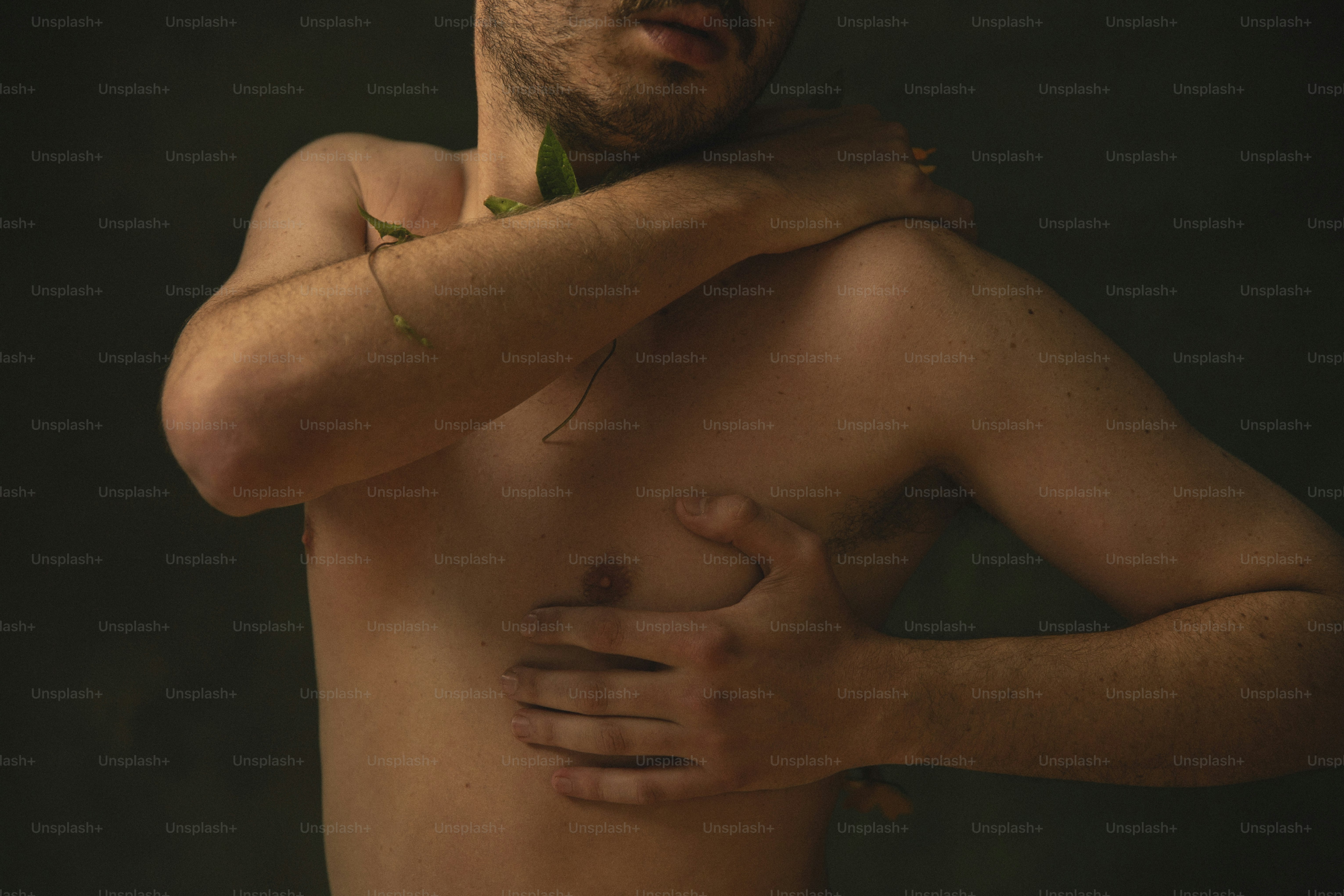 a man with no shirt holding his hands on his chest