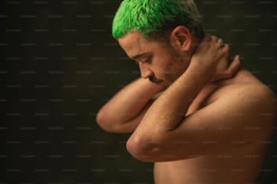 Un uomo a torso nudo con capelli verdi e pizzetto