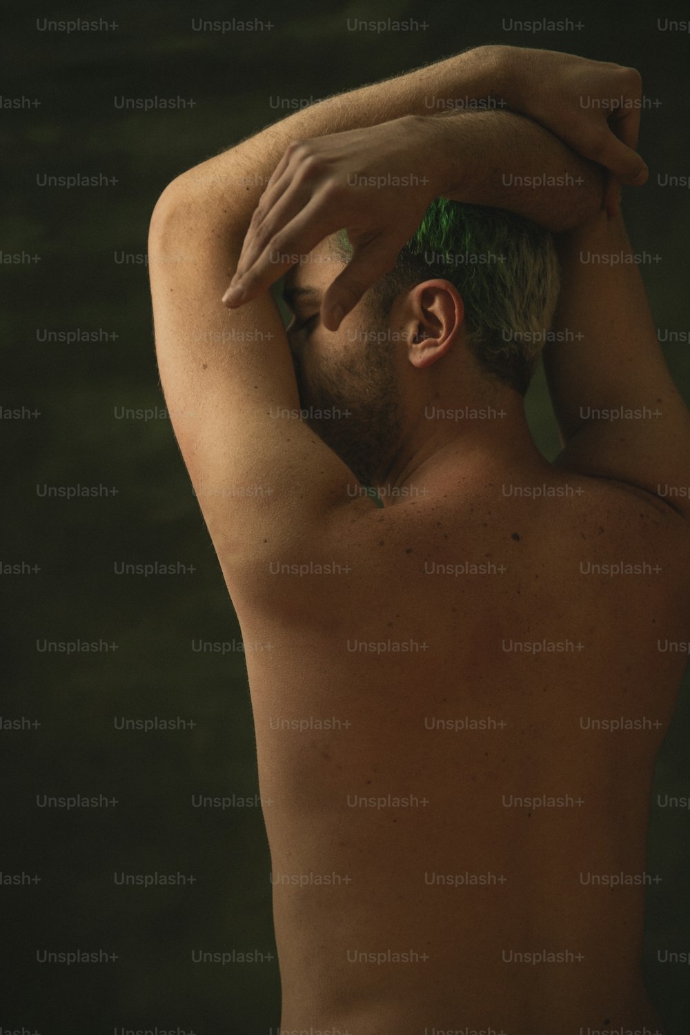 Un homme torse nu avec des cheveux verts et pas de chemise