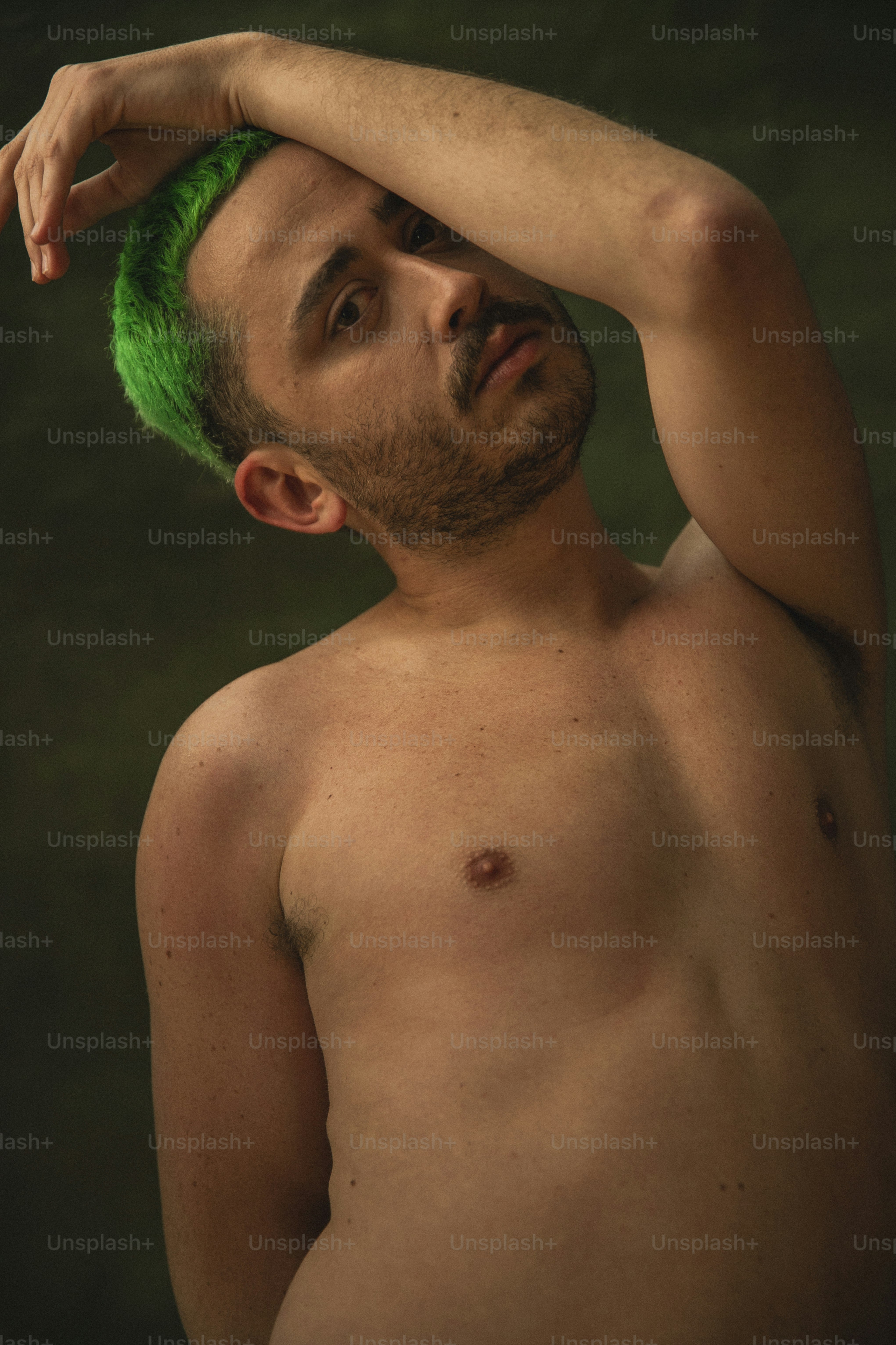 a shirtless man with a green mohawk