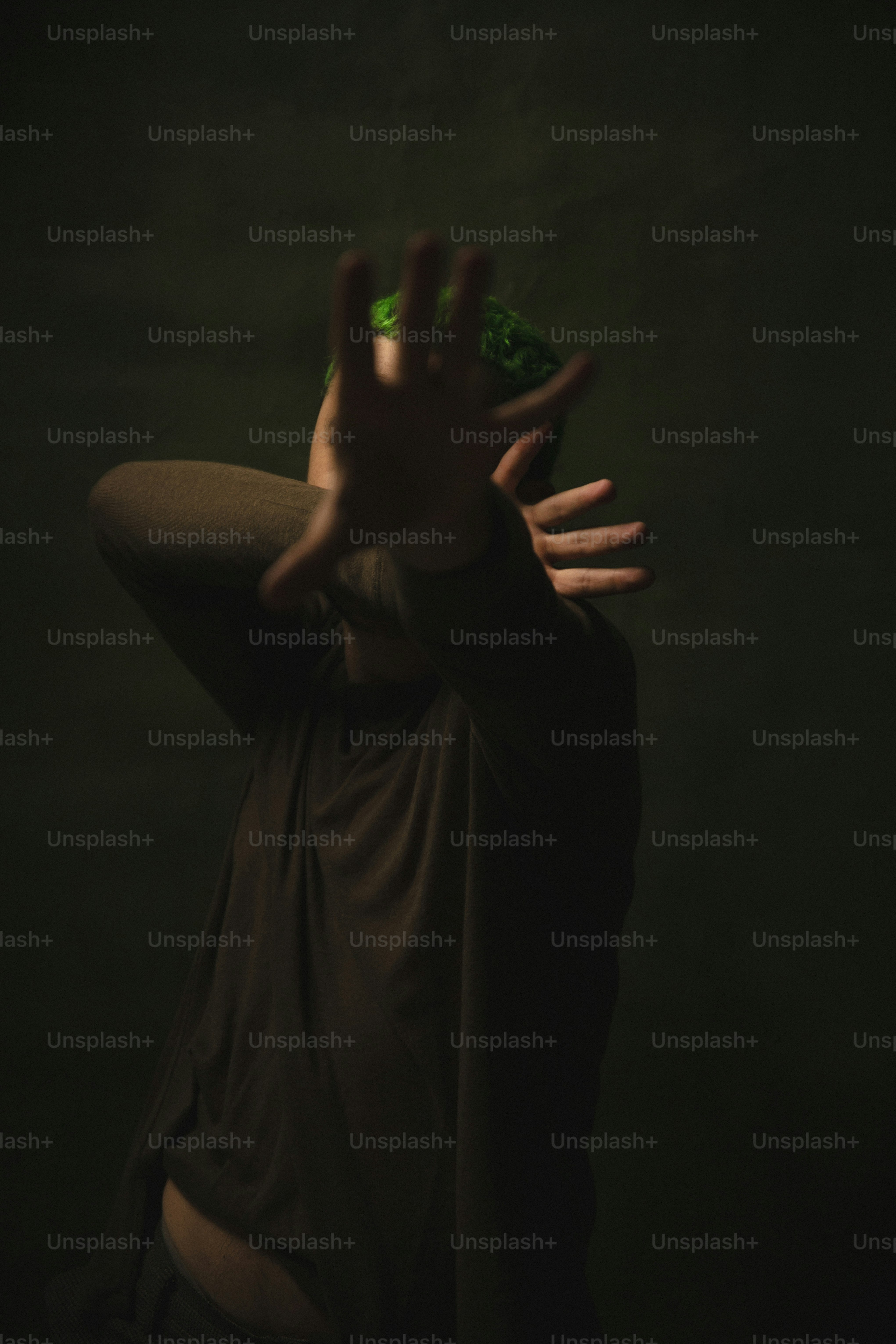 a person holding a bottle in the dark