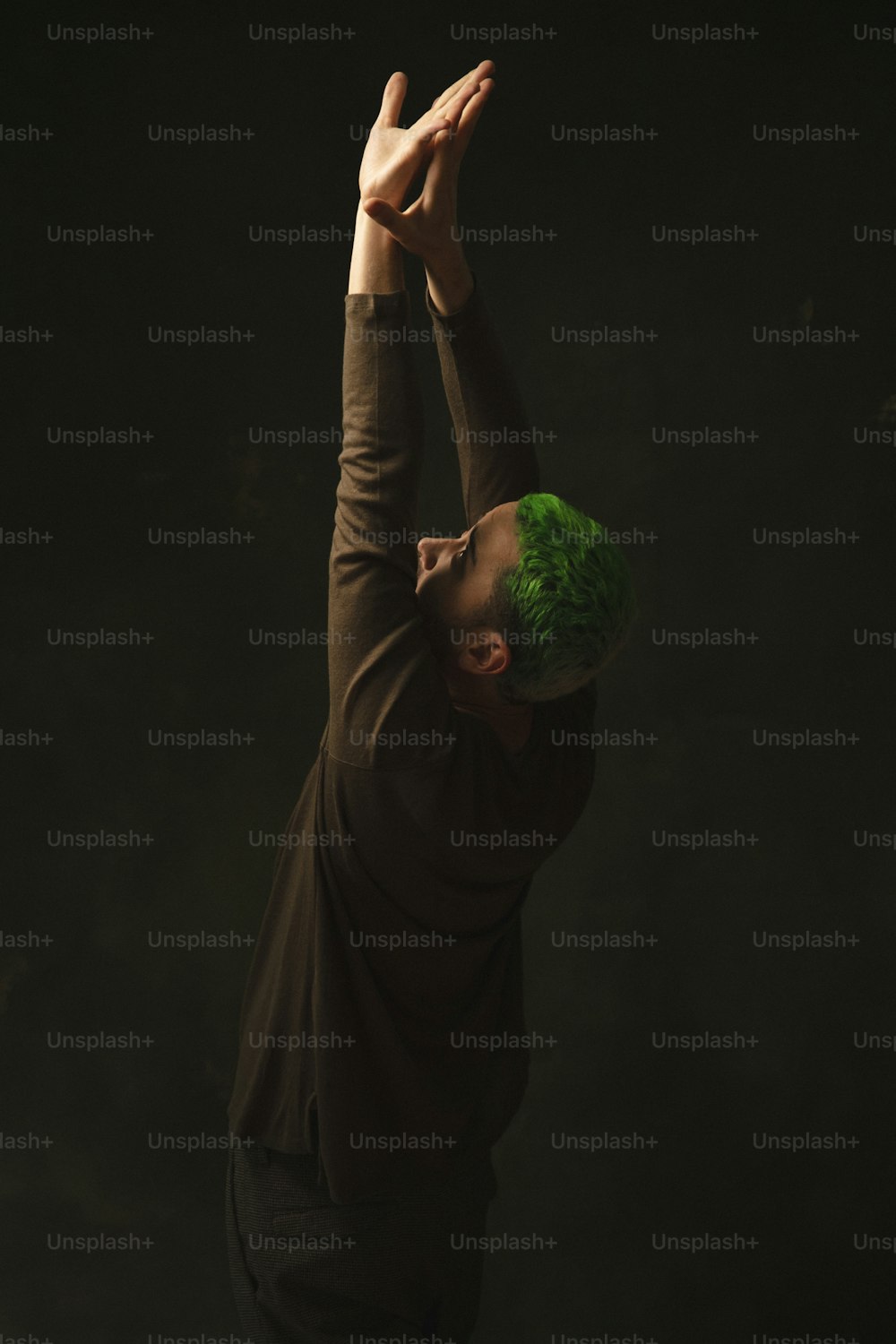 a man with green hair is doing a hand stand