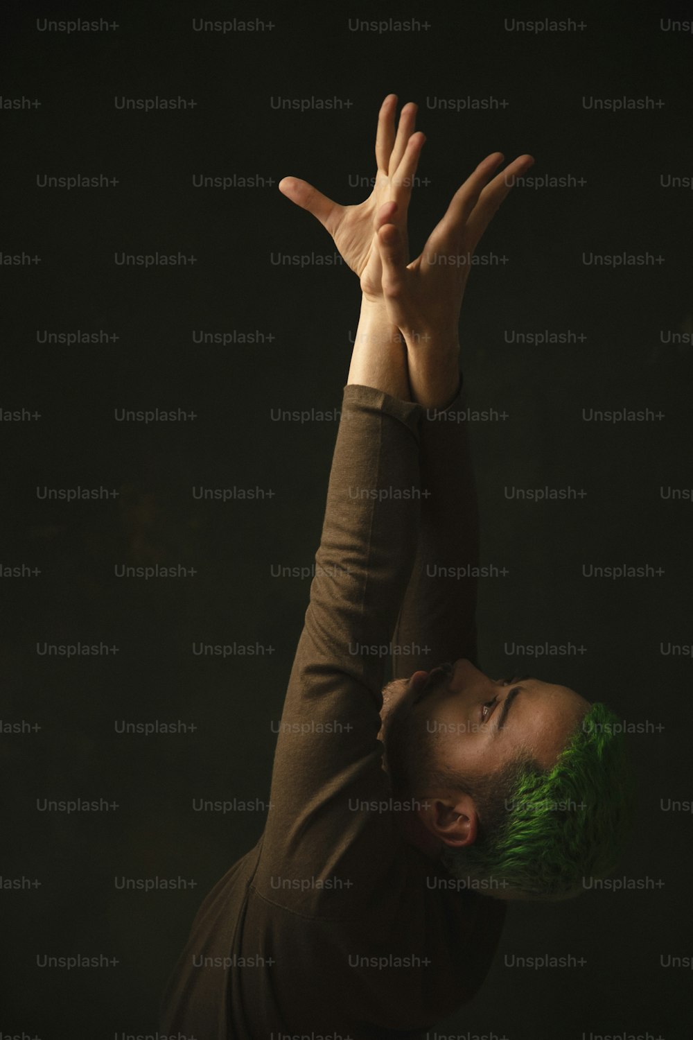 Un uomo con i capelli verdi sta facendo una posizione eretta