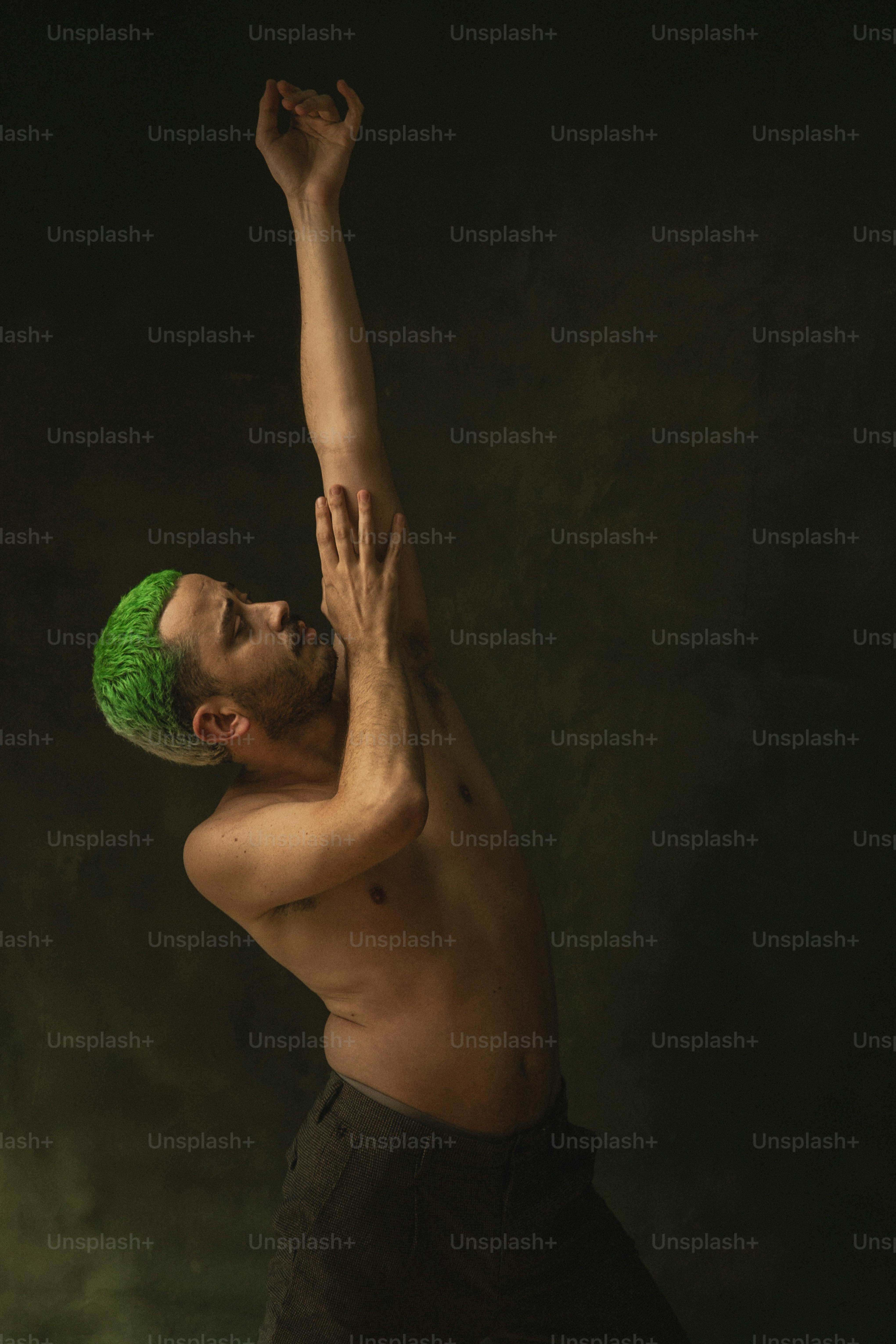 a shirtless man with a green wig on his head