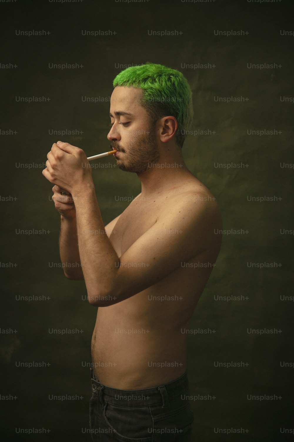 a man with green hair smoking a cigarette