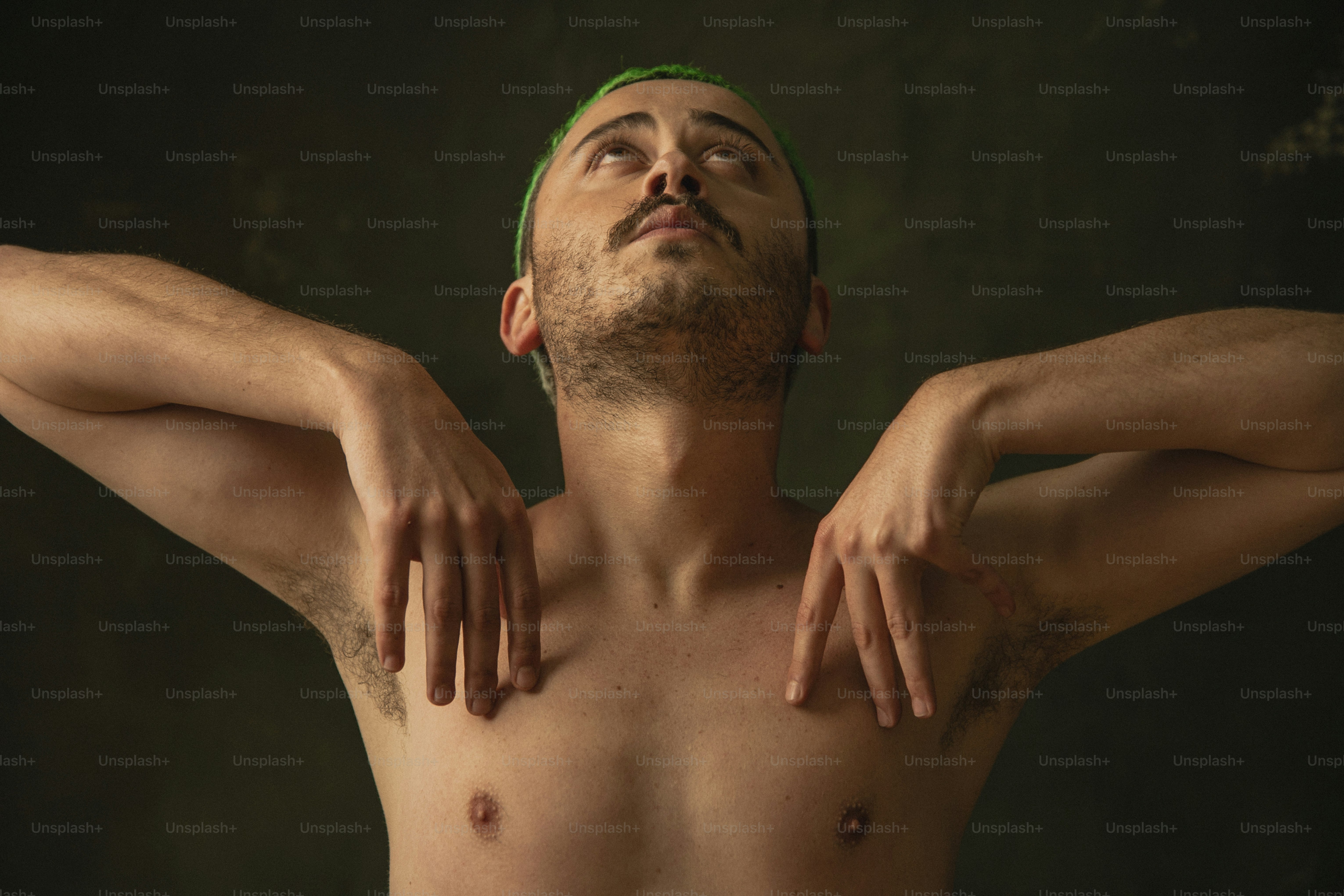 a shirtless man with his hands on his chest