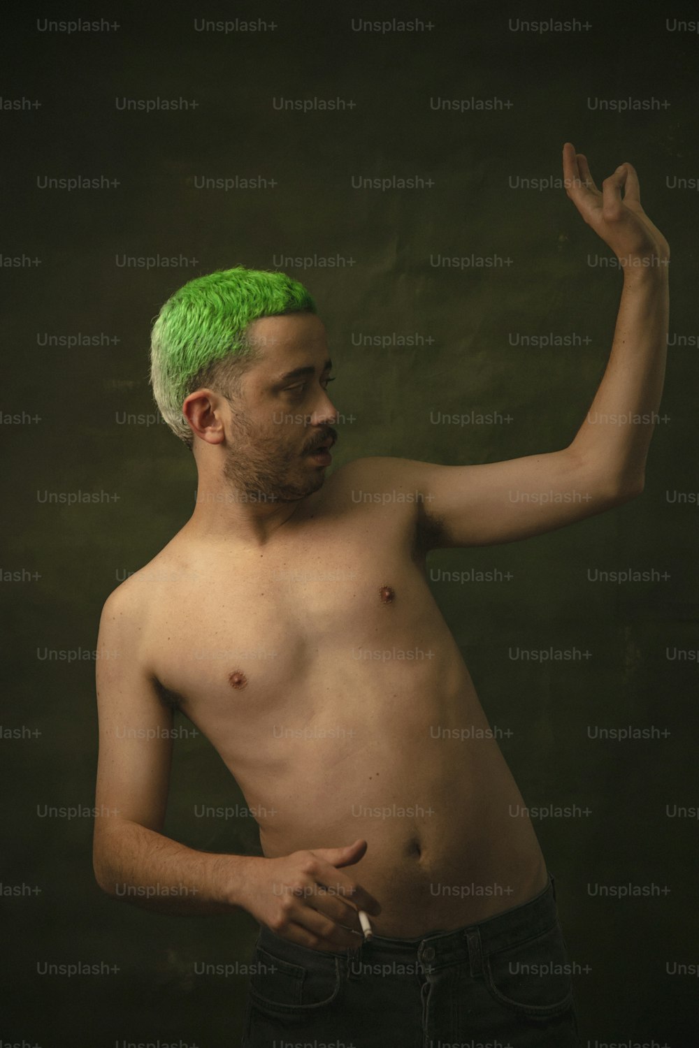 Un uomo a torso nudo con un mohawk verde