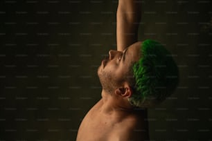 a shirtless man with green hair on his head