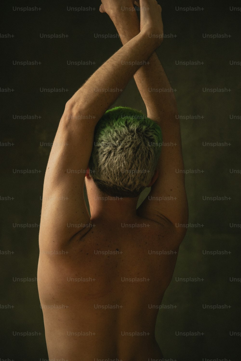 a shirtless man with a green hat on his head