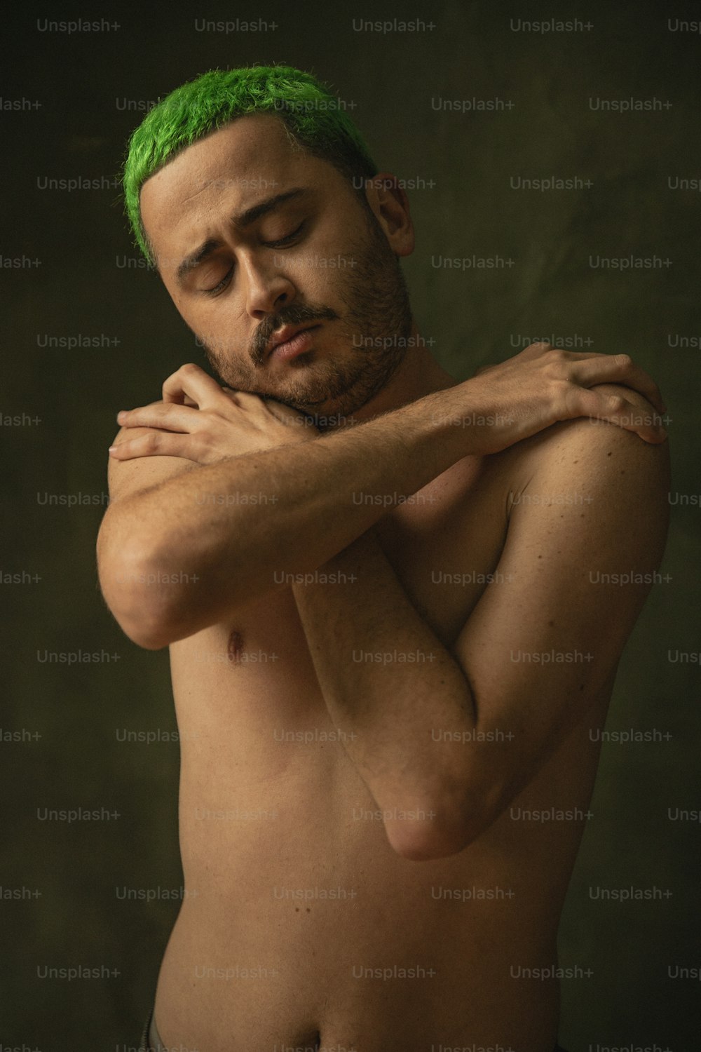 Un homme torse nu aux cheveux verts et sans chemise