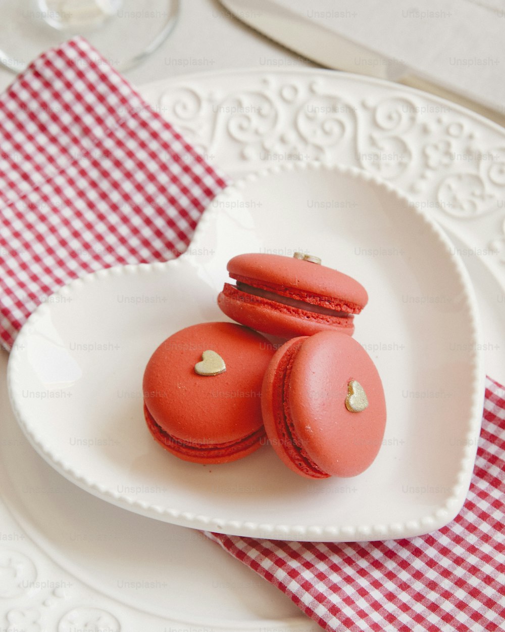 a white plate topped with three red macaroons