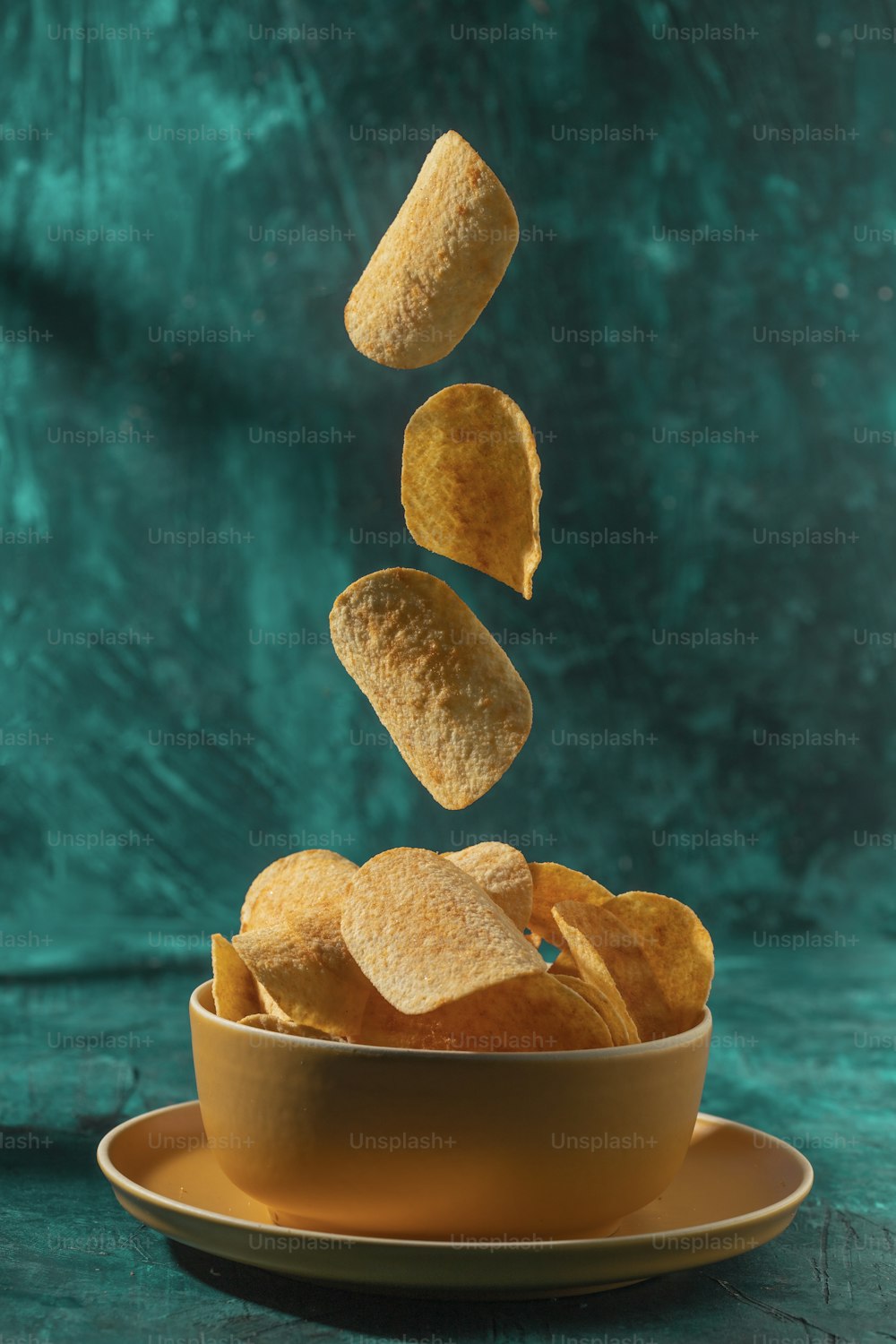 a bowl of chips falling into the air