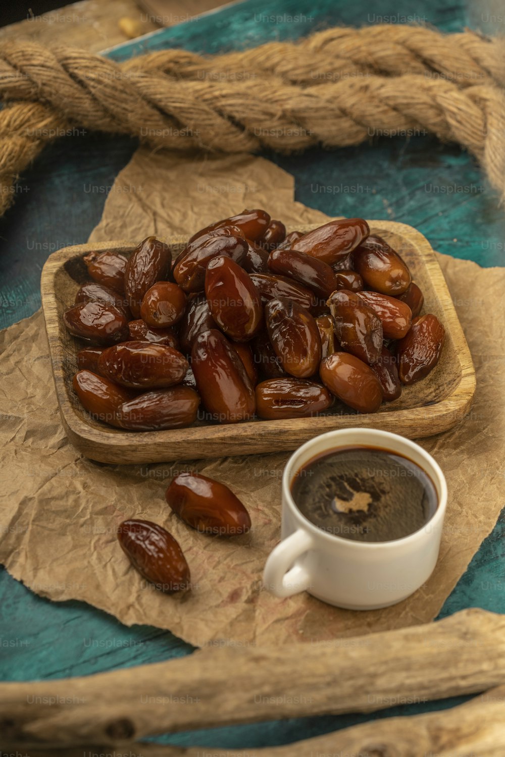 a cup of coffee next to a tray of dates