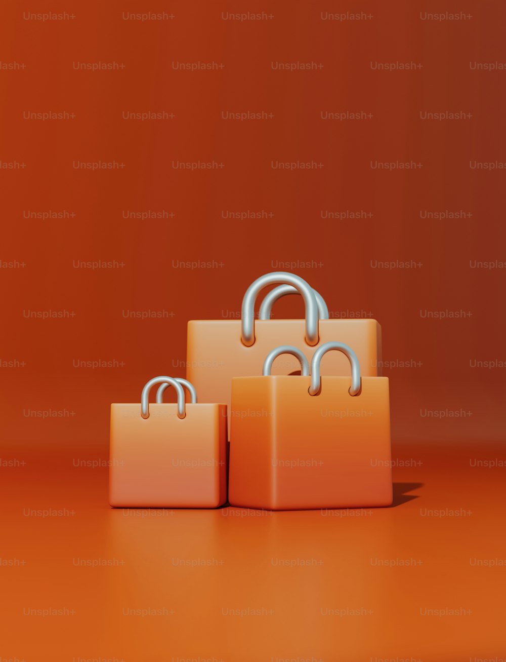 three orange shopping bags sitting on top of an orange surface