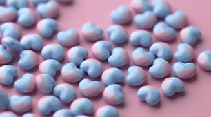 a pile of blue and pink candy hearts on a pink background