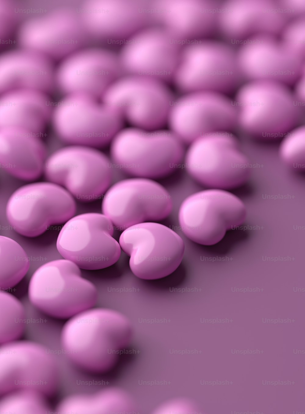 Ein Haufen rosa Bonbonkugeln auf einer violetten Oberfläche