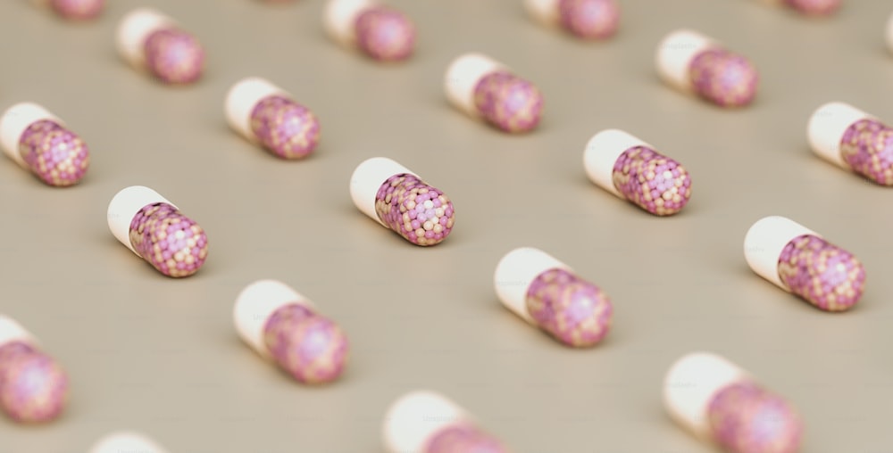 a group of pink and white pills sitting on top of a table