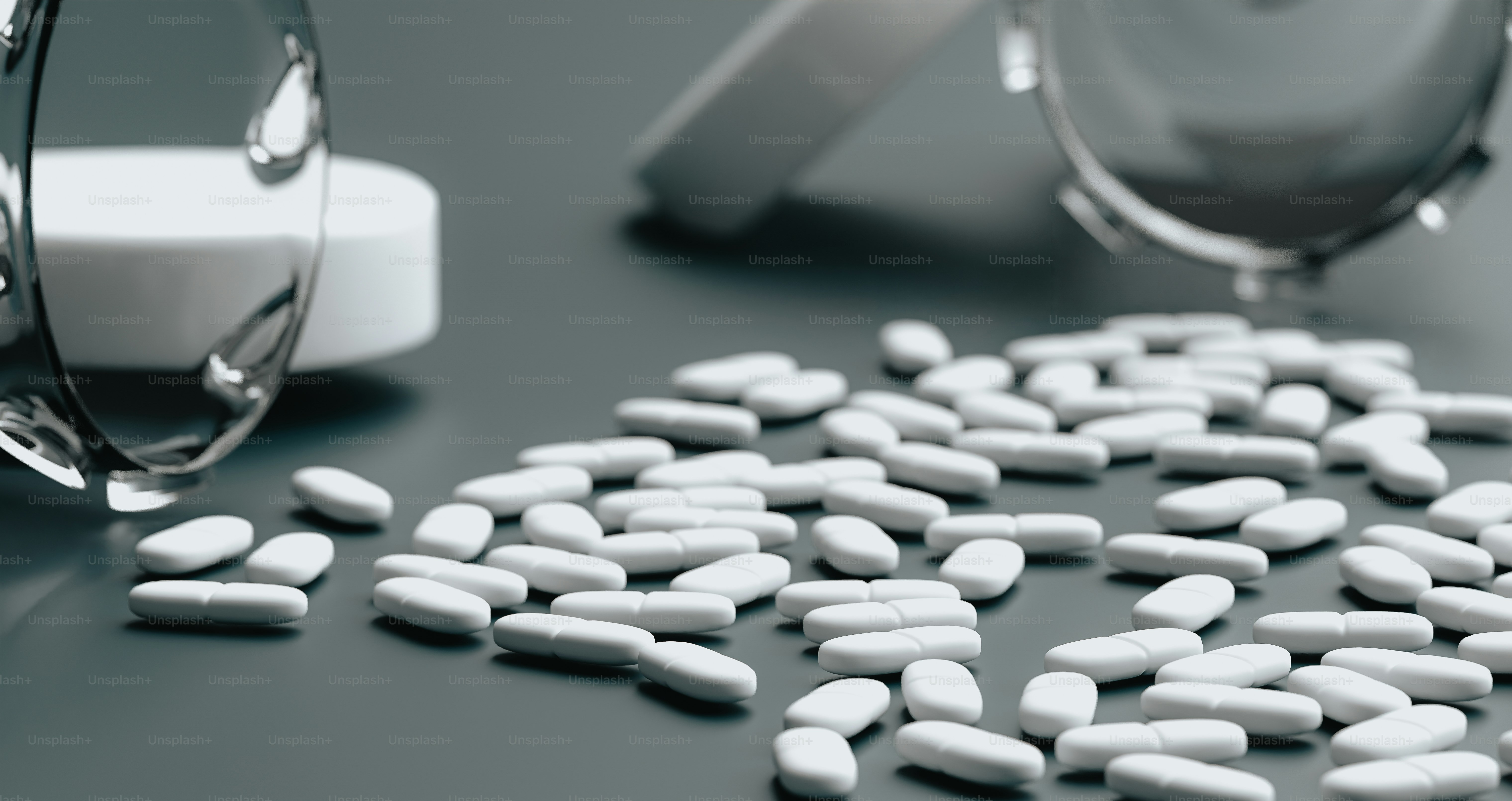 a close up of many pills near a pill bottle