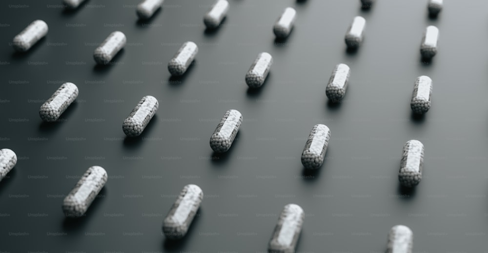 Un gruppo di pillole bianche sedute sopra una superficie nera