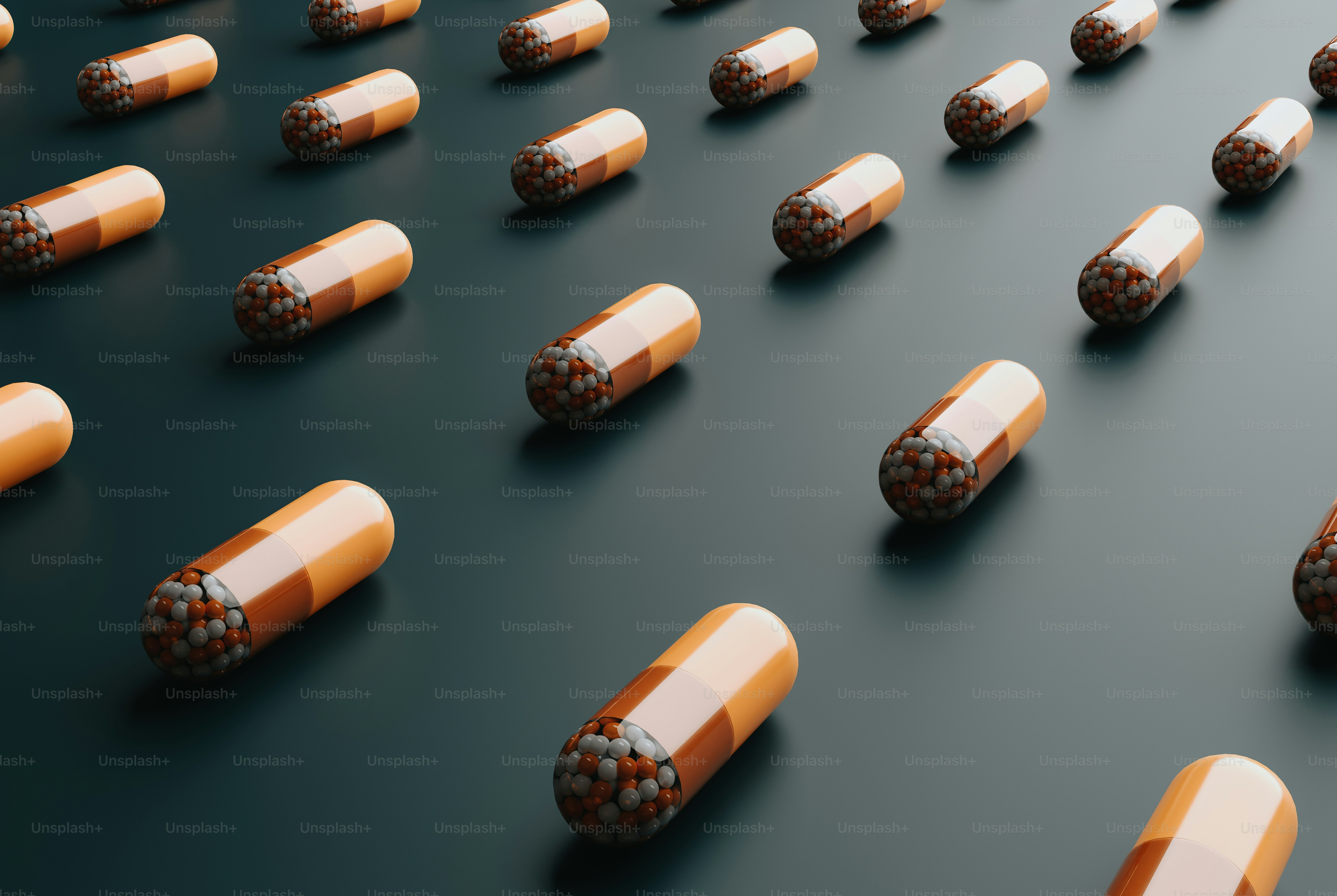 a group of orange and white pills on a black surface