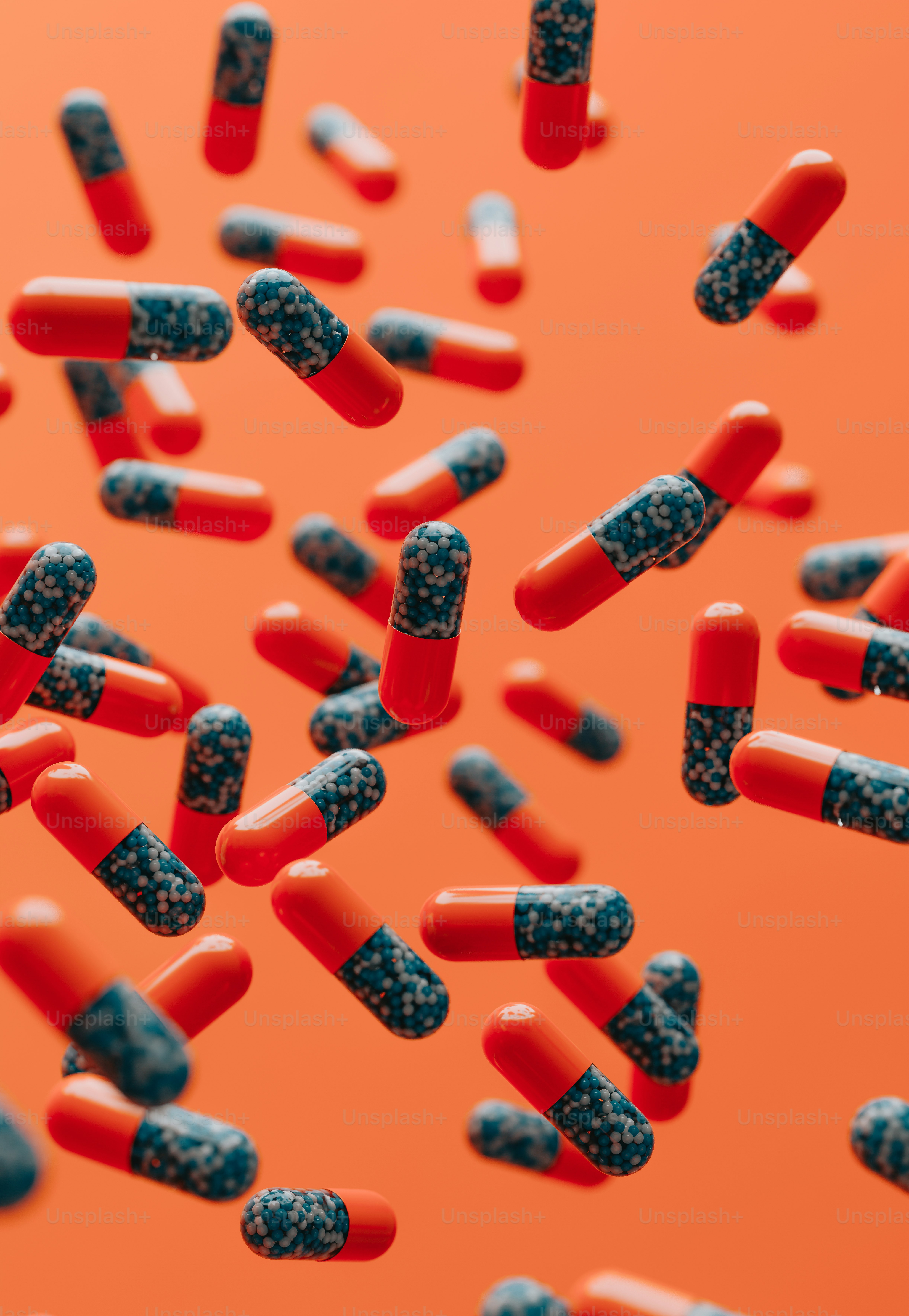 Un montón de pastillas rojas y negras sobre un fondo naranja