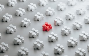 um grupo de pílulas brancas e vermelhas sentadas uma em cima da outra