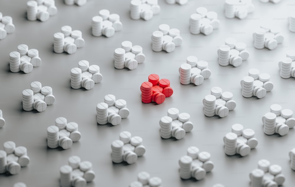 Un gruppo di pillole bianche e rosse sedute una sopra l'altra