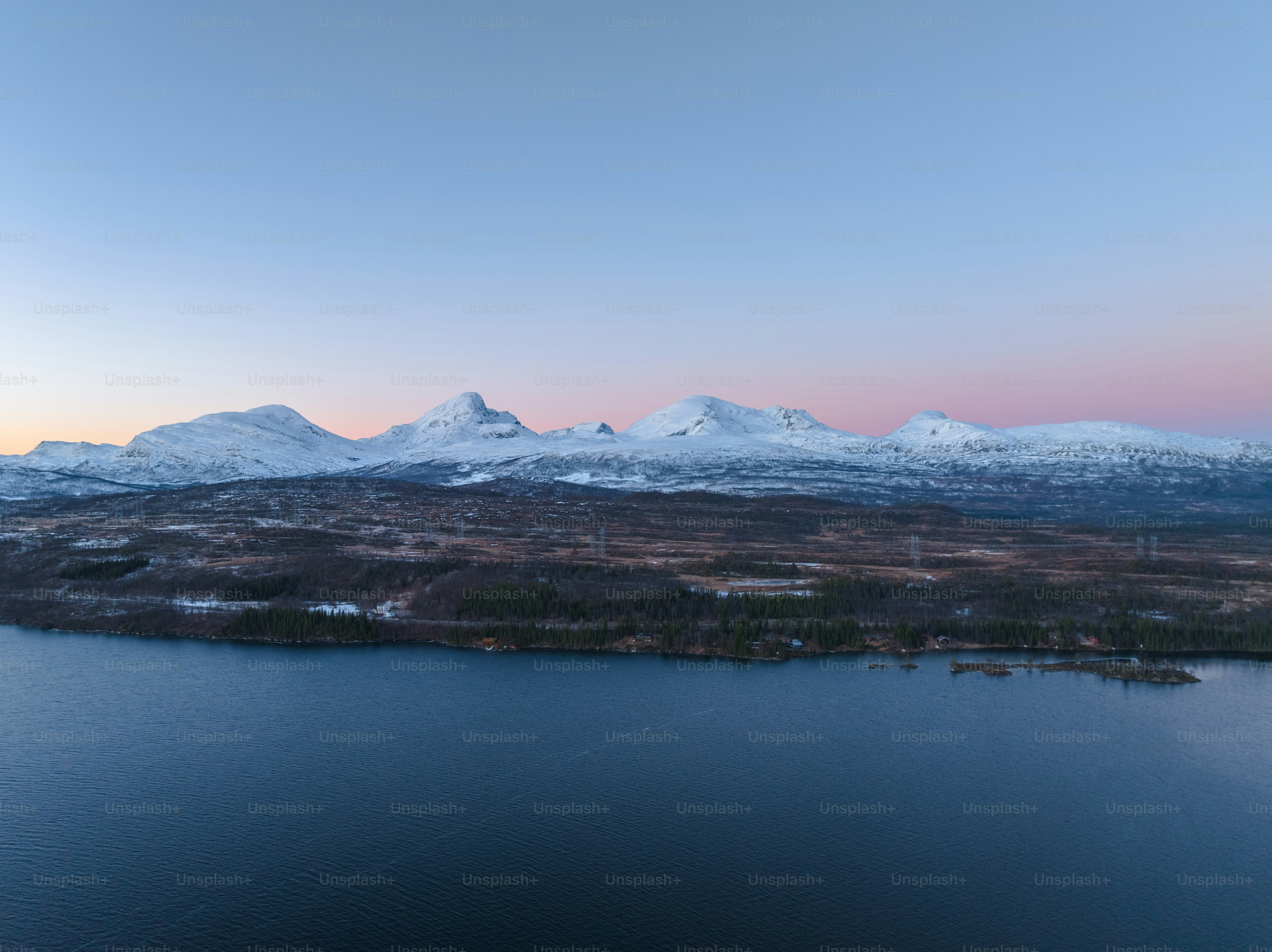 a large body of water surrounded by snow covered mountains