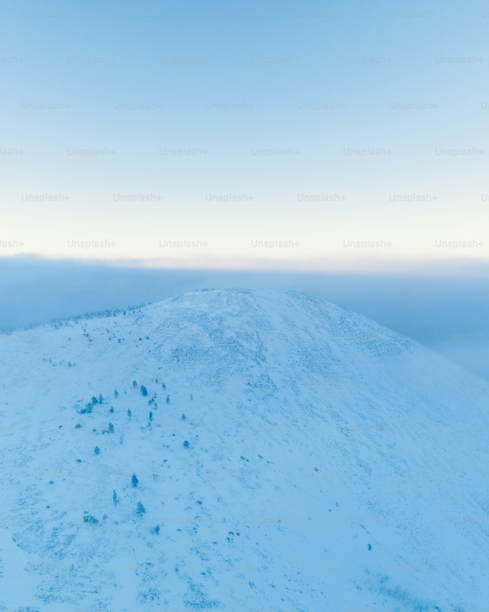 Ein schneebedeckter Hügel unter blauem Himmel