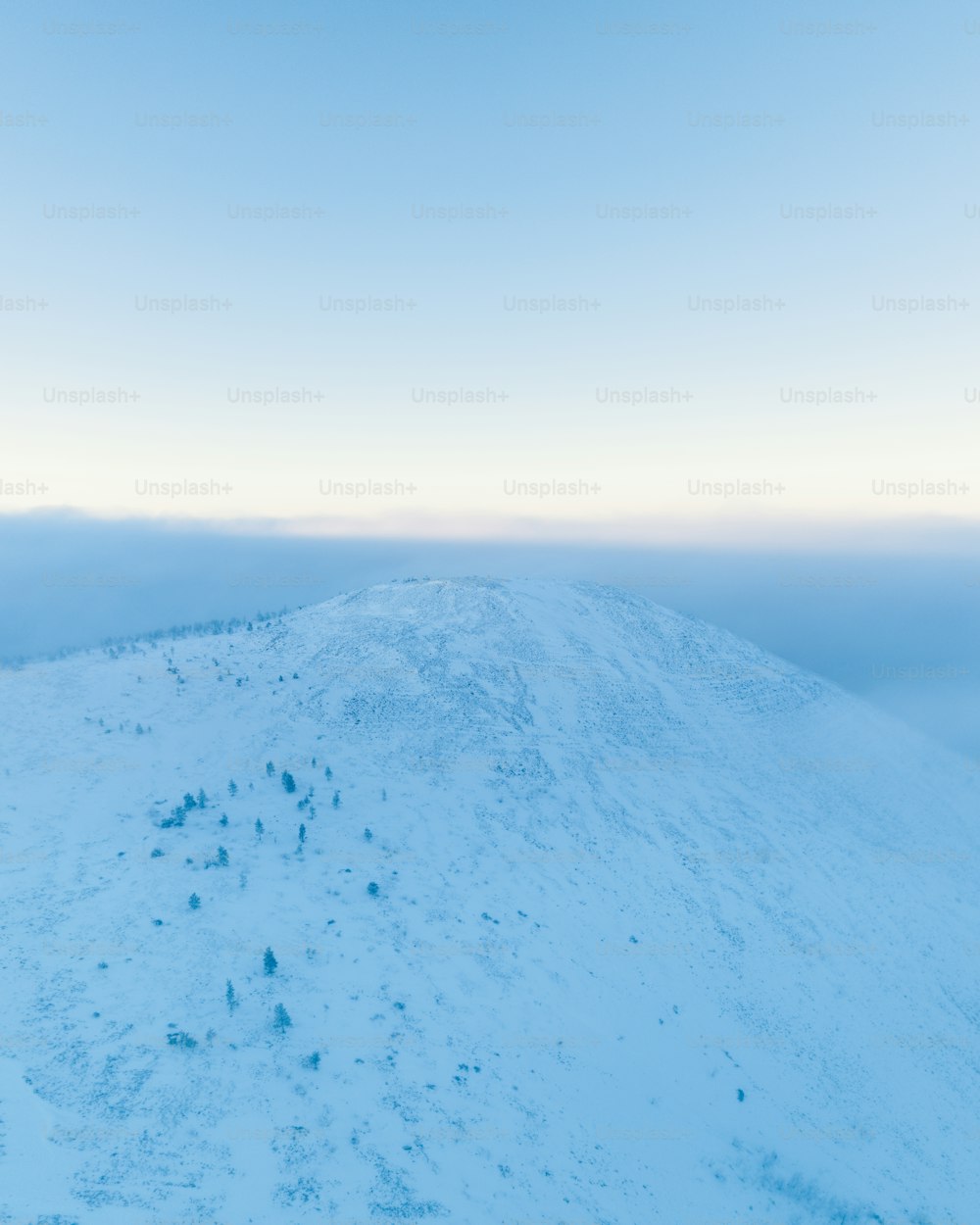 a hill covered in snow under a blue sky