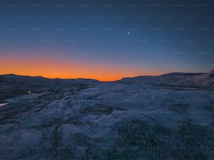 the sun is setting over a mountain range