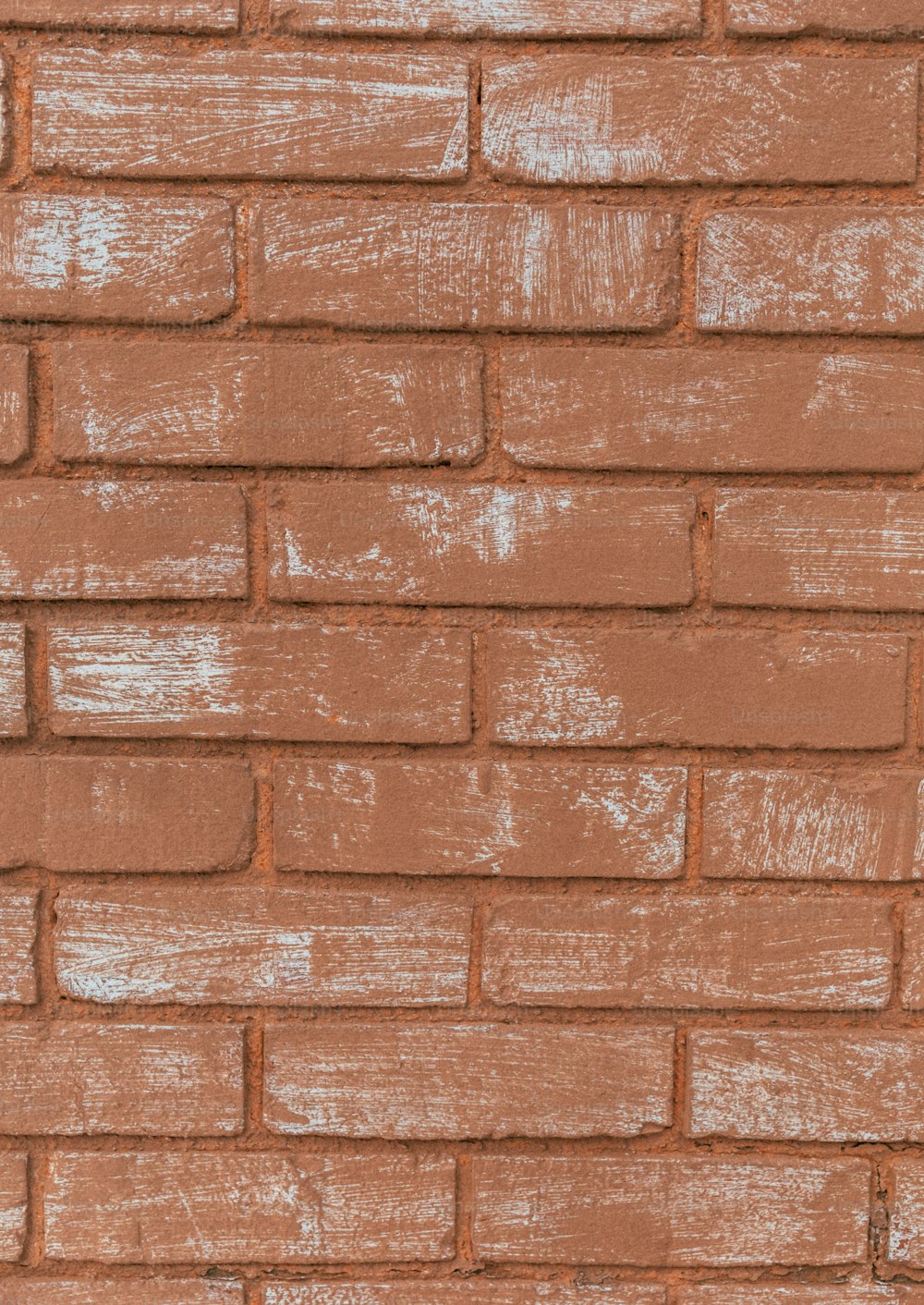 a close up of a brick wall with white paint