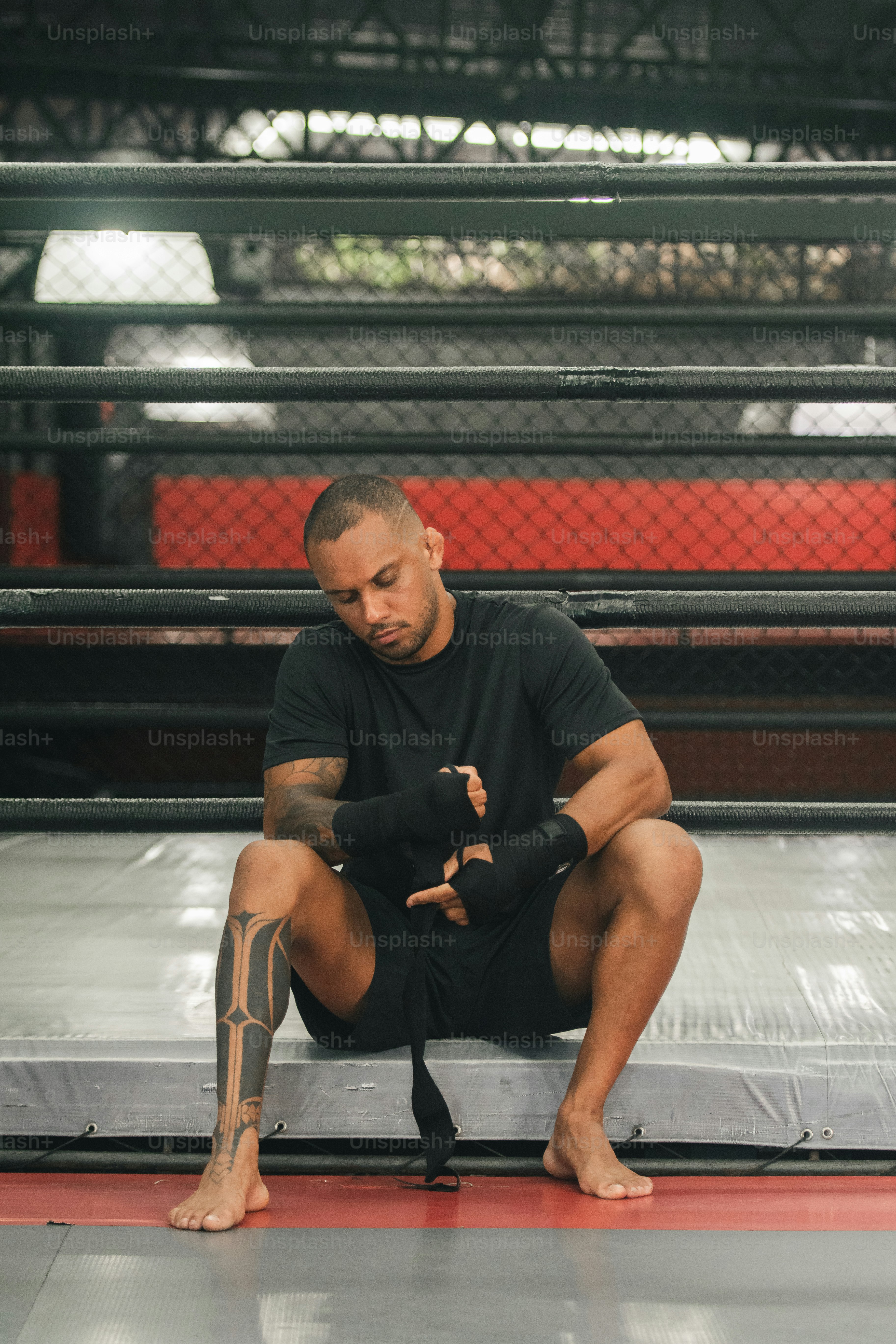 a man sitting on top of a wrestling mat