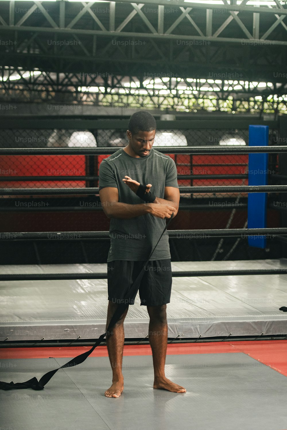 a man standing in a ring looking at his cell phone