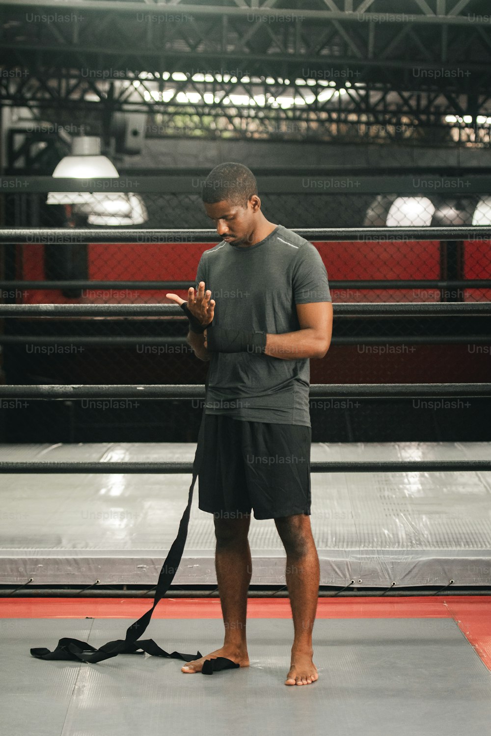 a man standing in front of a boxing ring using a cell phone