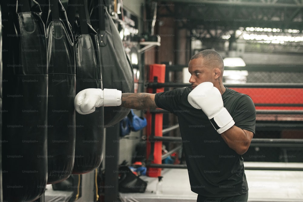 a man wearing boxing gloves is punching a punching bag