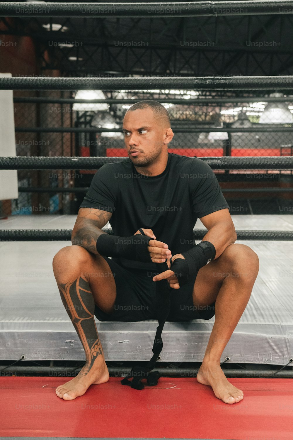 um homem sentado em cima de um ringue de luta livre
