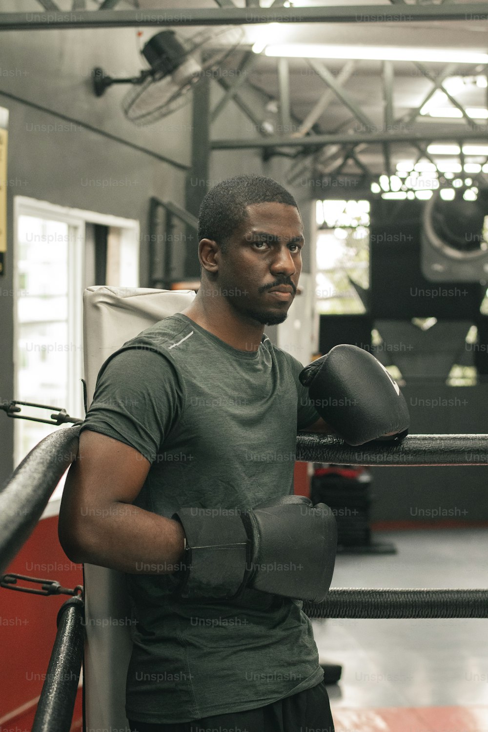 Un hombre en un gimnasio sosteniendo un guante de boxeo