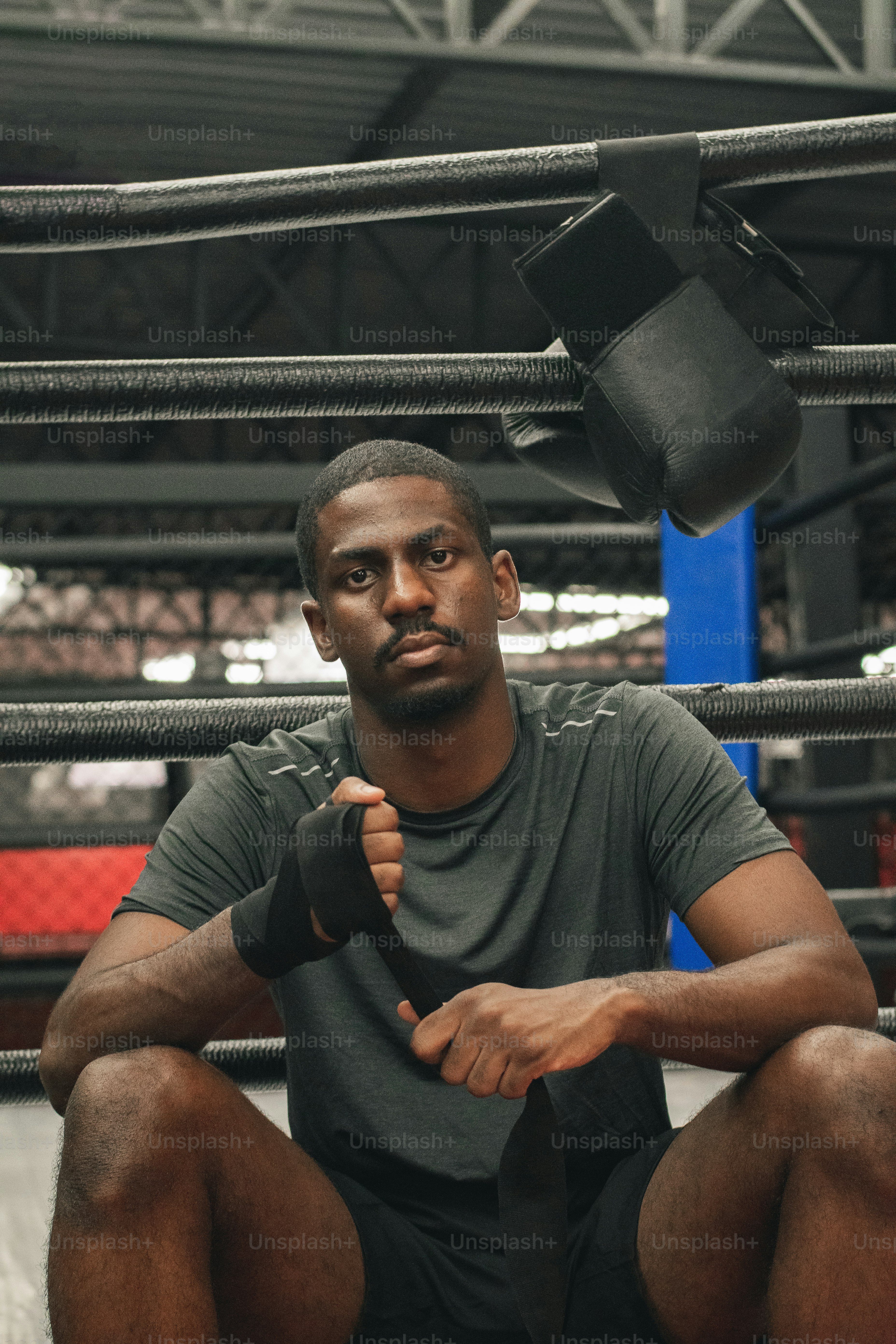 a man sitting on the ground in a boxing ring