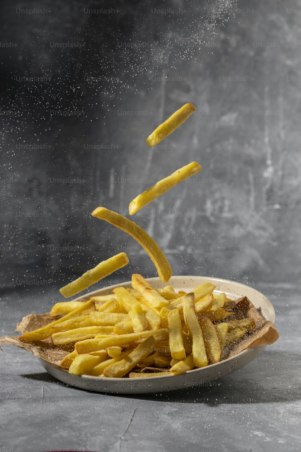 a plate of french fries falling into the air
