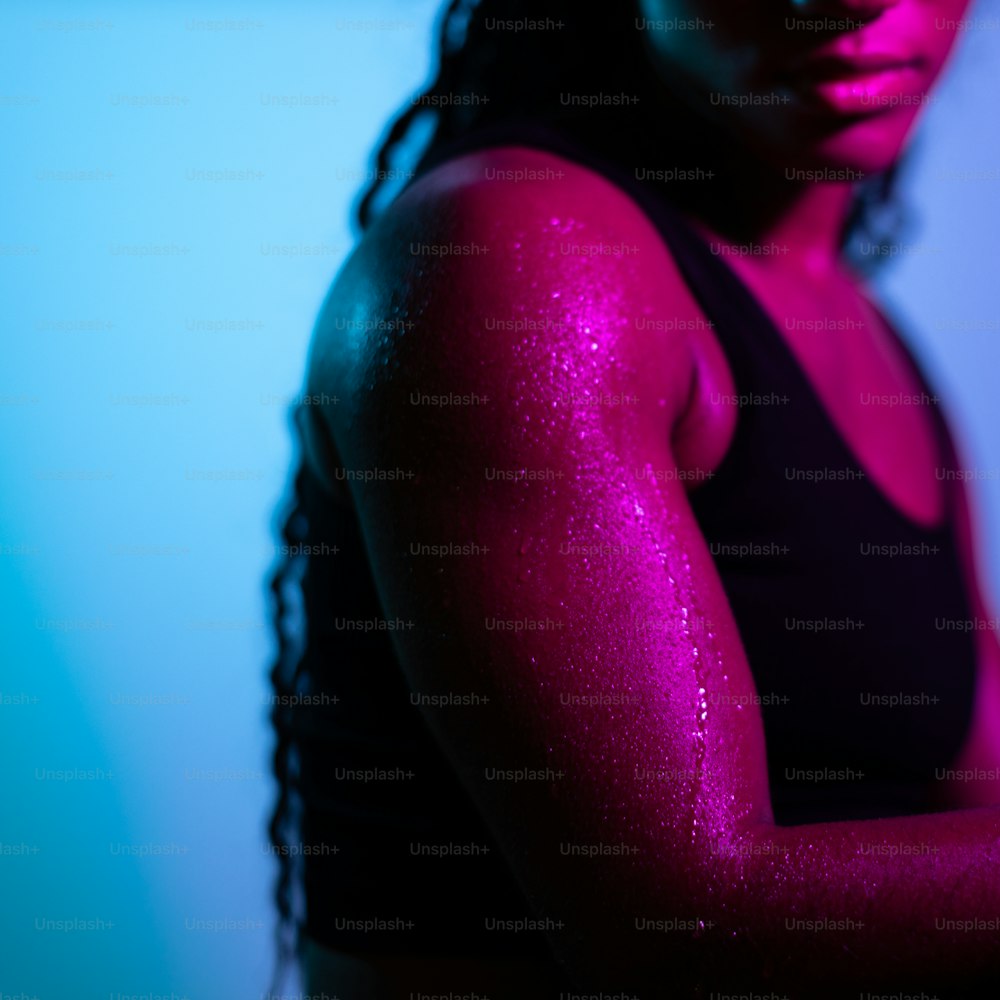 a woman in a black tank top with pink powder on her arm