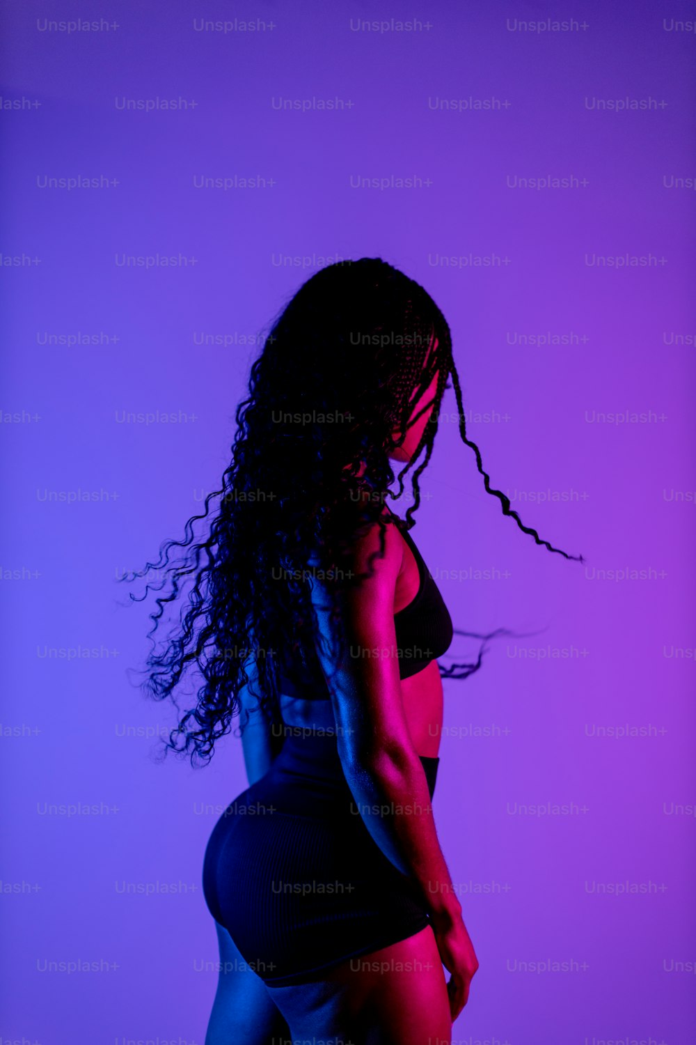 a woman with long hair standing in a dark room