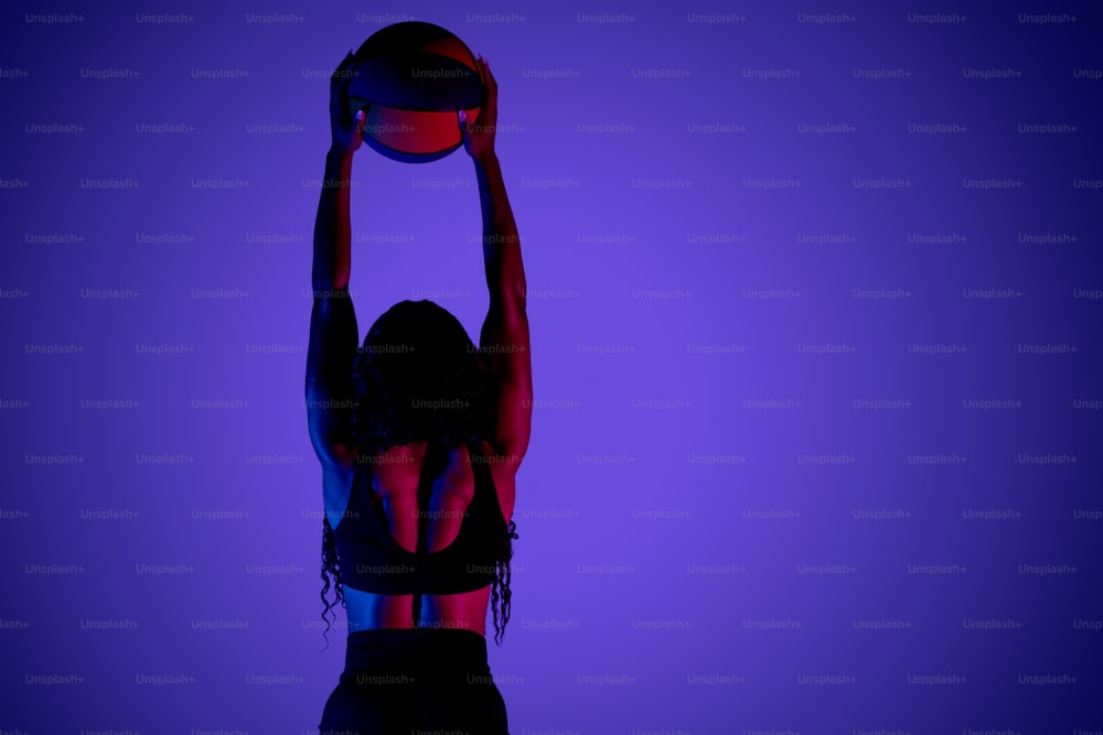 a woman holding a basketball up in the air