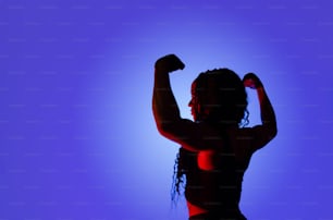 a silhouette of a woman with her arms raised