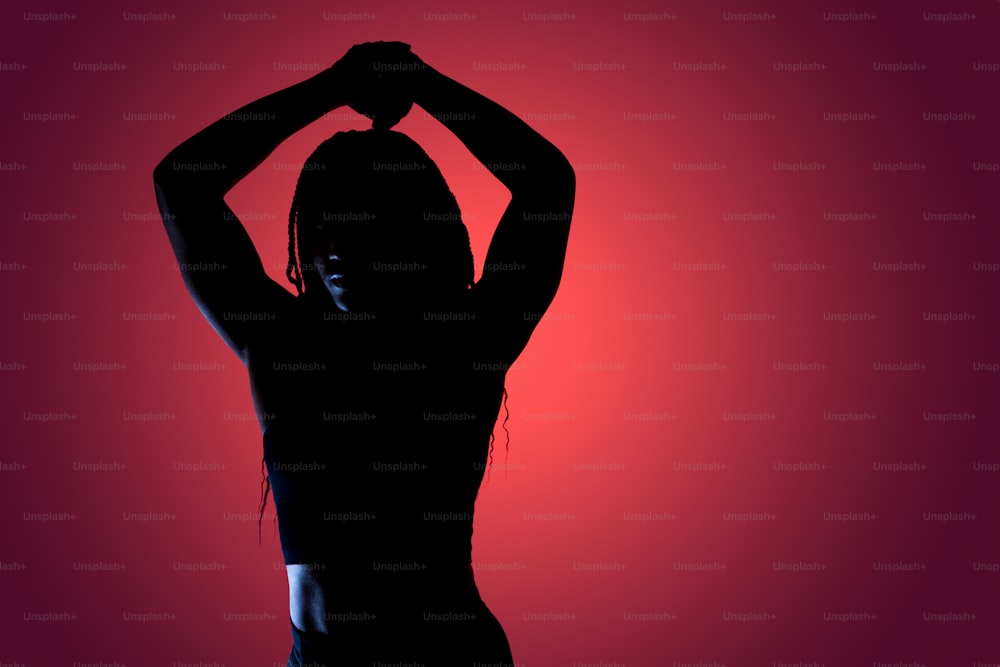 a silhouette of a woman with her hands on her head