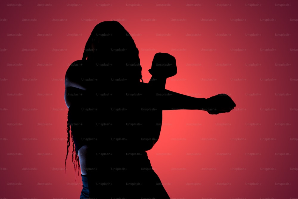 a silhouette of a woman holding a baseball bat