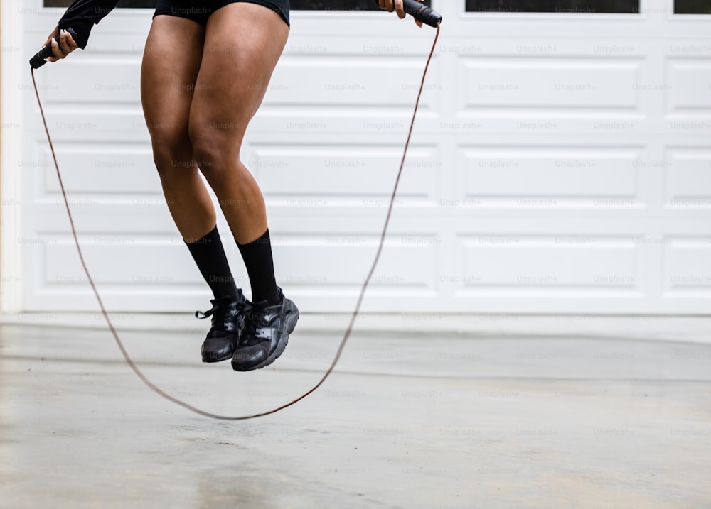 a woman is jumping with a jump rope