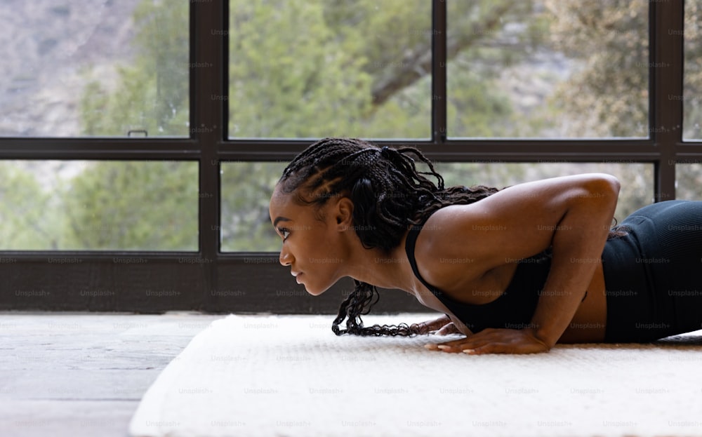 a woman is doing a yoga pose on a mat