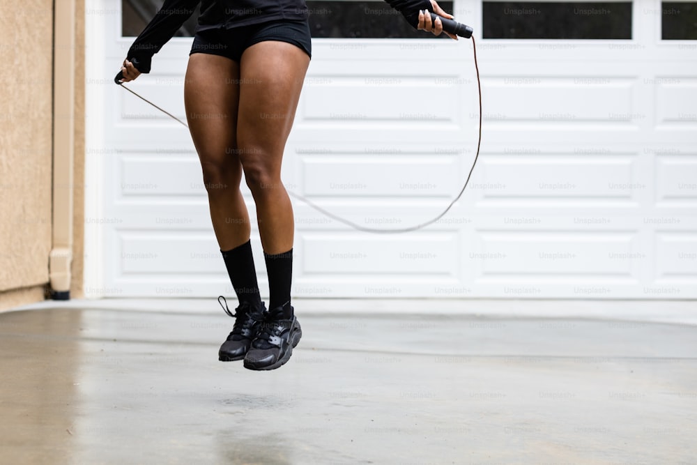 a woman jumping in the air with a jump rope