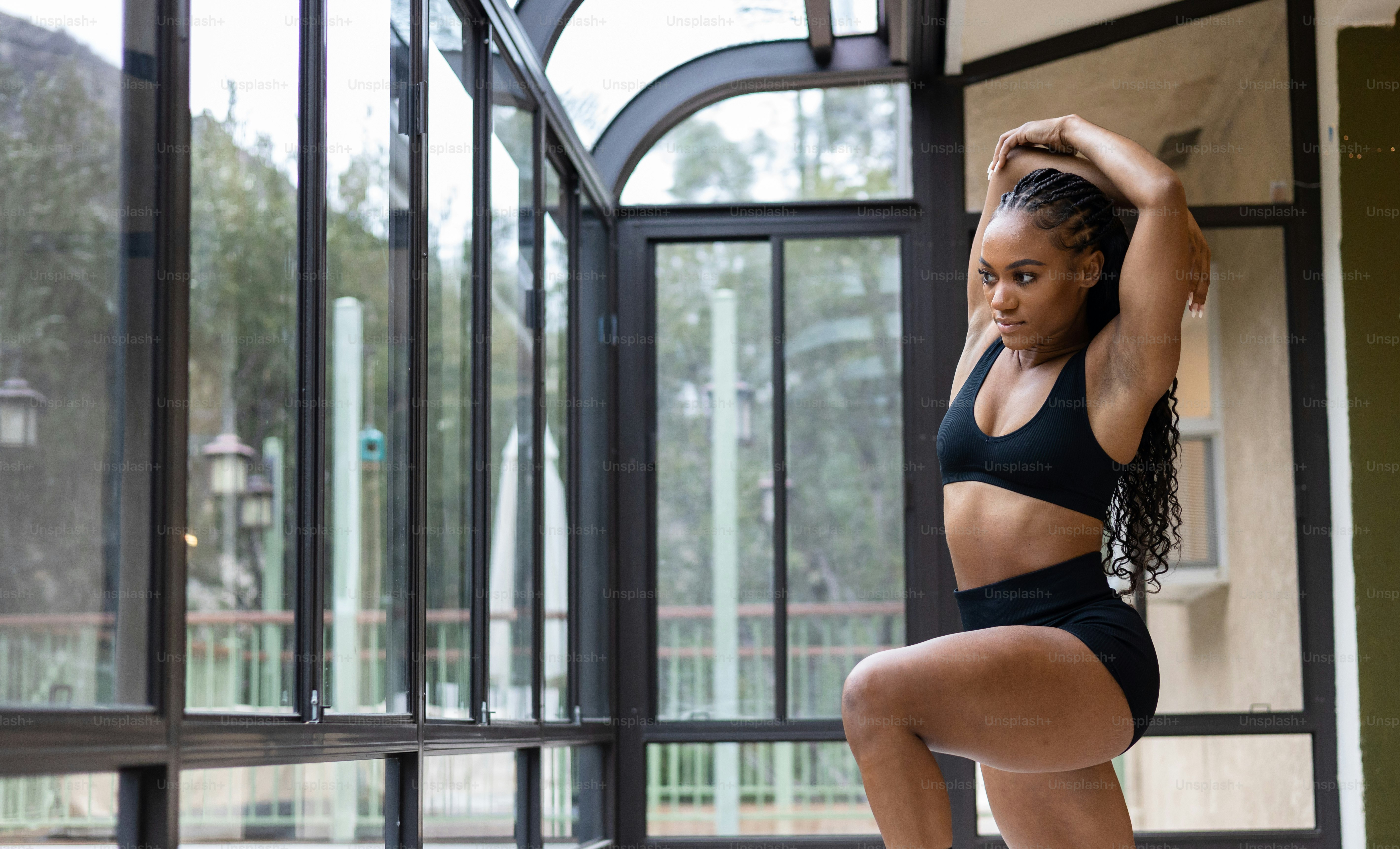 a woman in a black sports bra top and black shorts